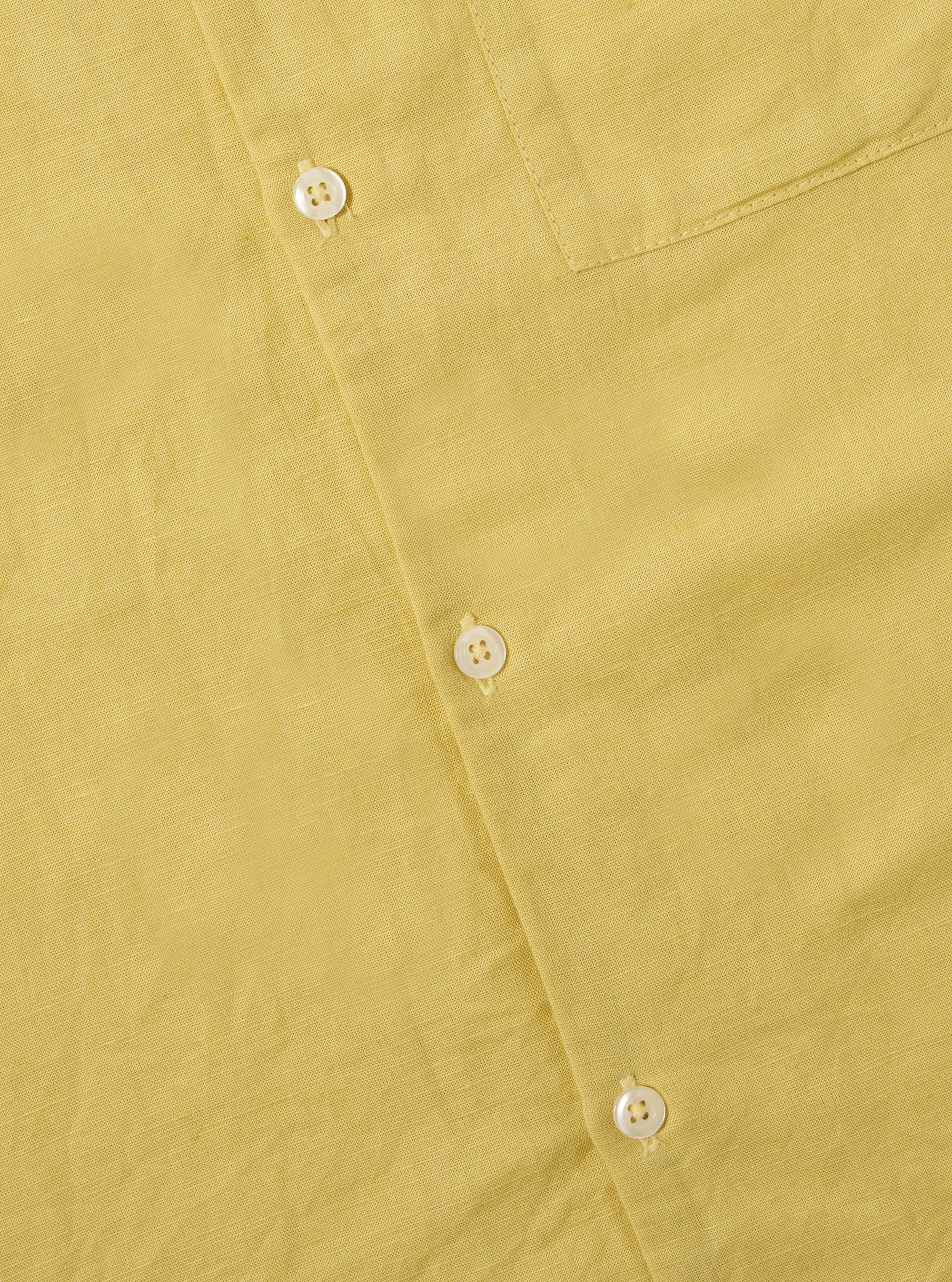 Close-up of the lemon-colored Lemon Linen Cotton Shirting Camp Shirt, showcasing the fabric texture, buttons, and pocket detail on a flat surface.
