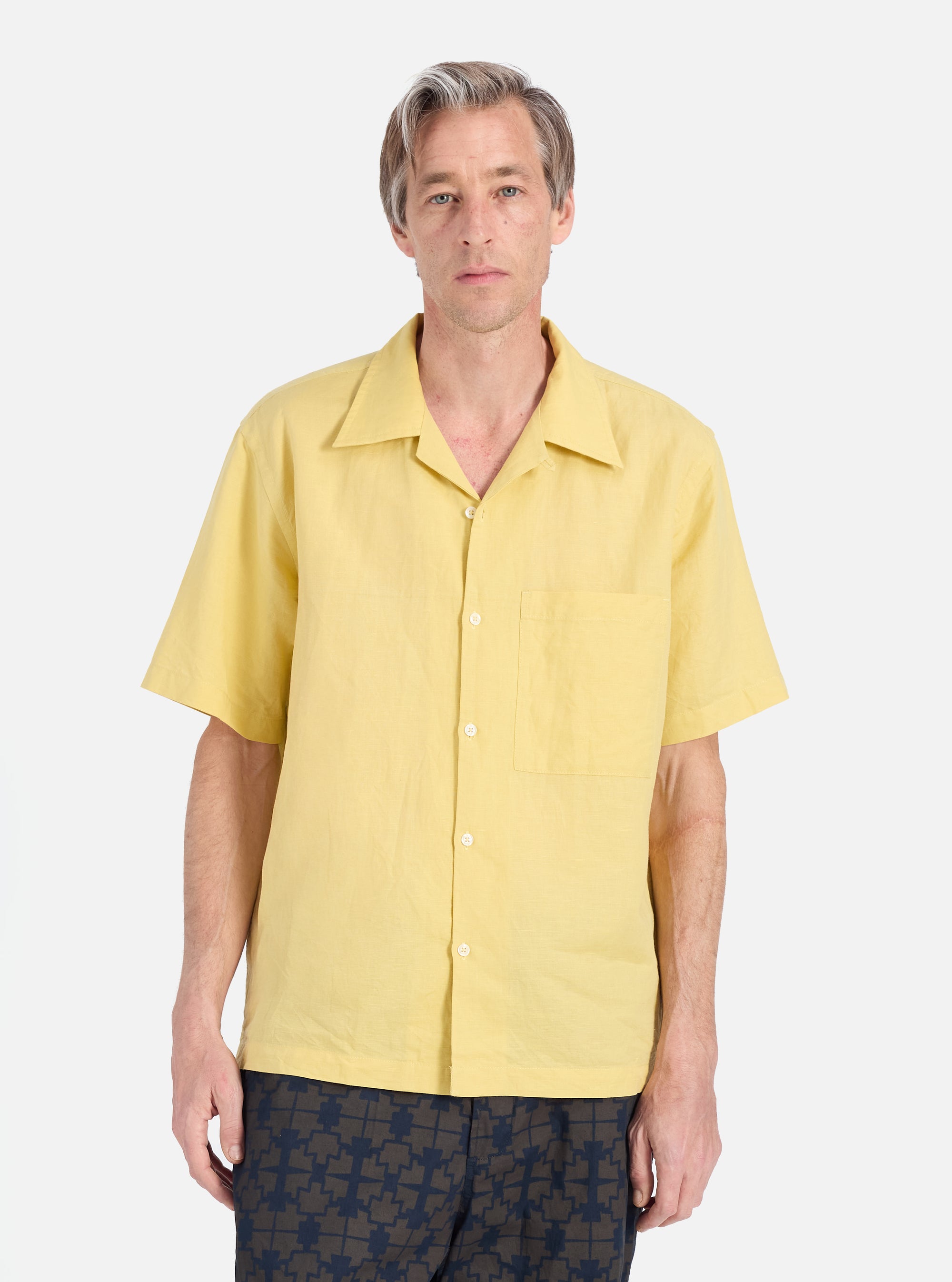 A model on a white background wears a Lemon Linen Cotton Shirting Camp Shirt. The shirt is a light yellow color and has a relaxed fit.