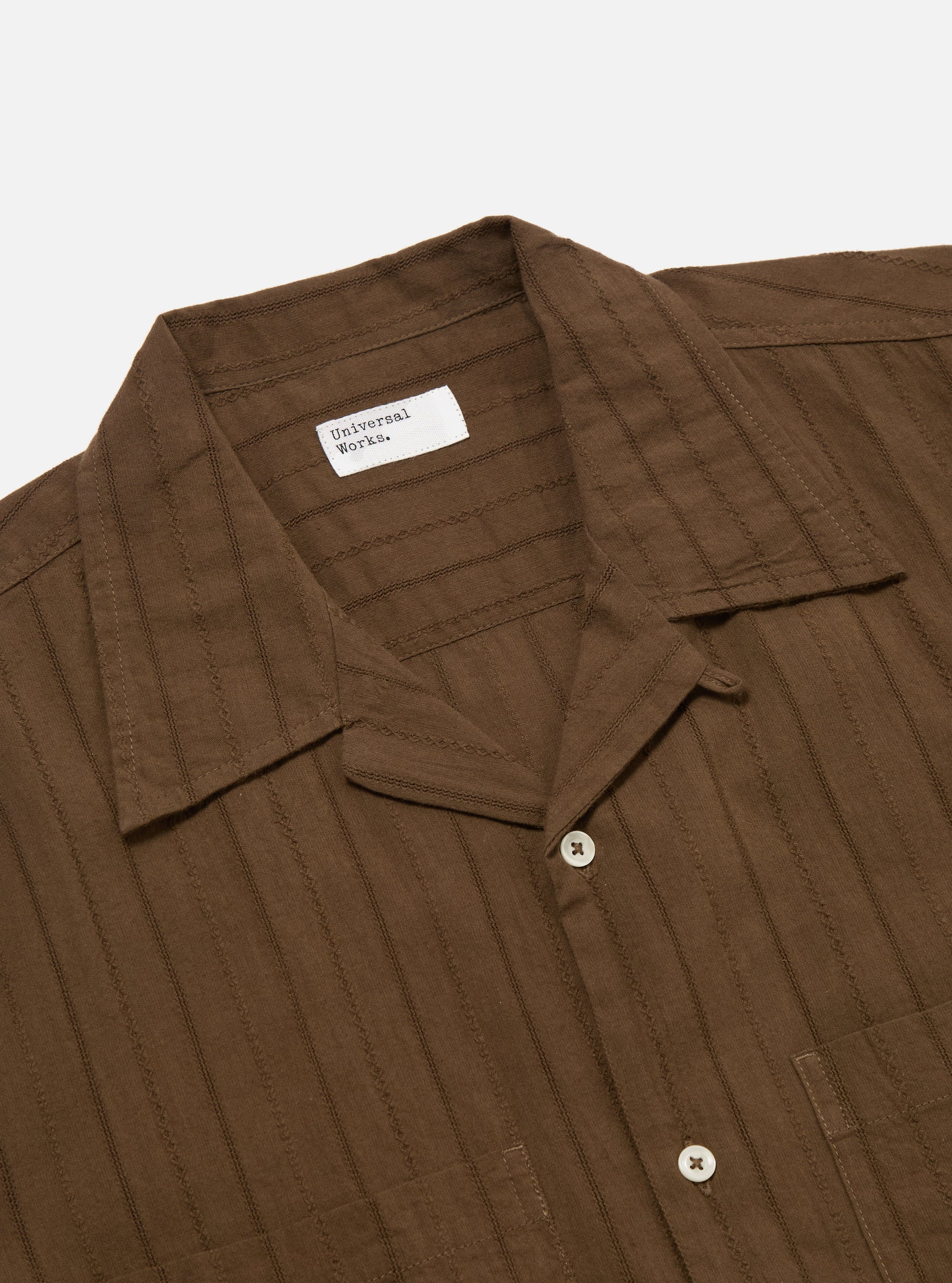 Close-up of the Brown Dobby Self Stripe Camper Shirt on a white background. The brown shirt has a subtle vertical stripe pattern and white buttons.