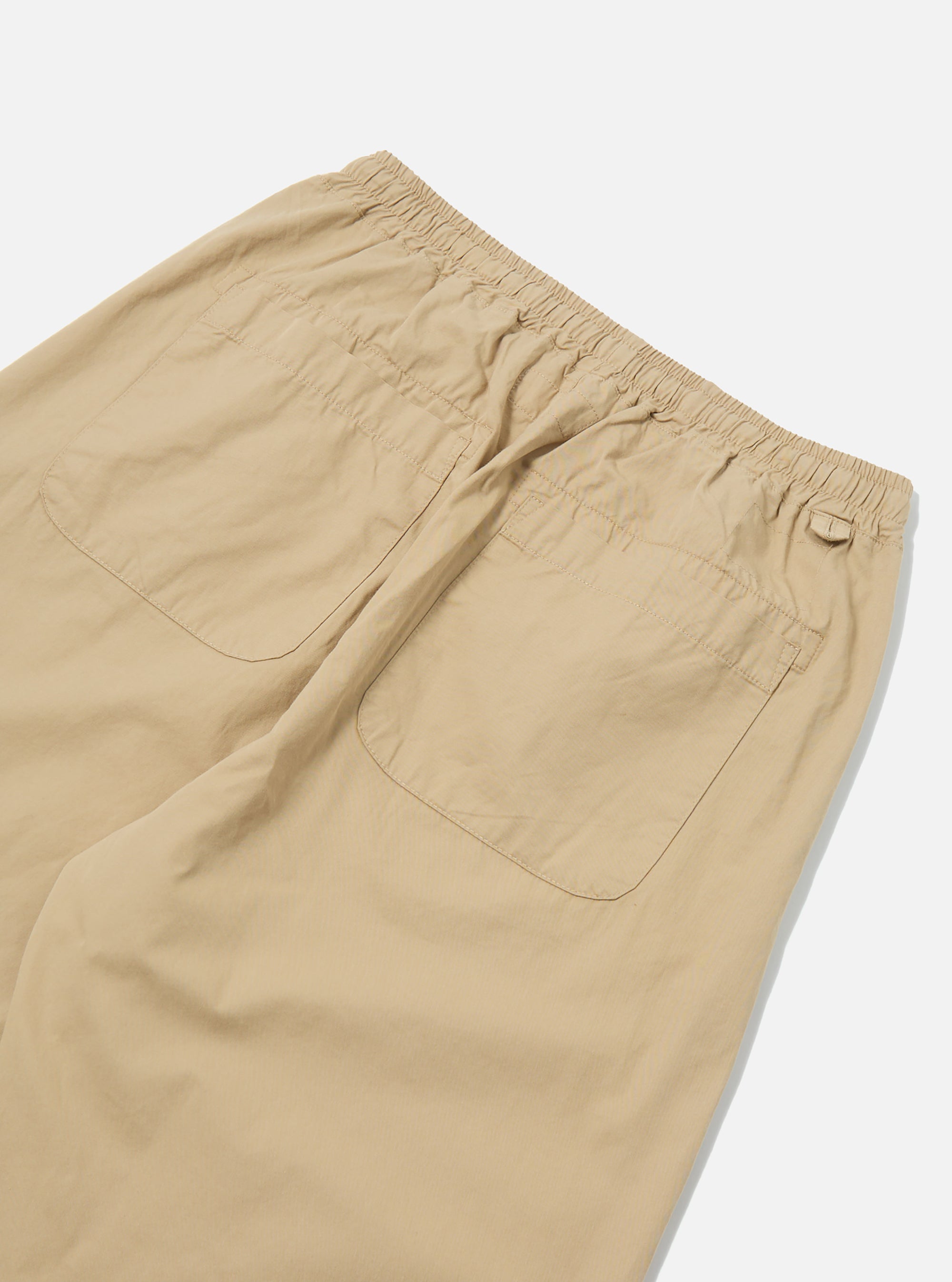 Close-up of the back of sand-colored military cotton Judo Pant on a white surface. The pants have an elastic waistband and two back pockets.