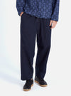 Model wears Navy Military Cotton Judo Pant in studio. These loose-fitting, navy cotton pants are paired with black sneakers. The background is a clean white.
