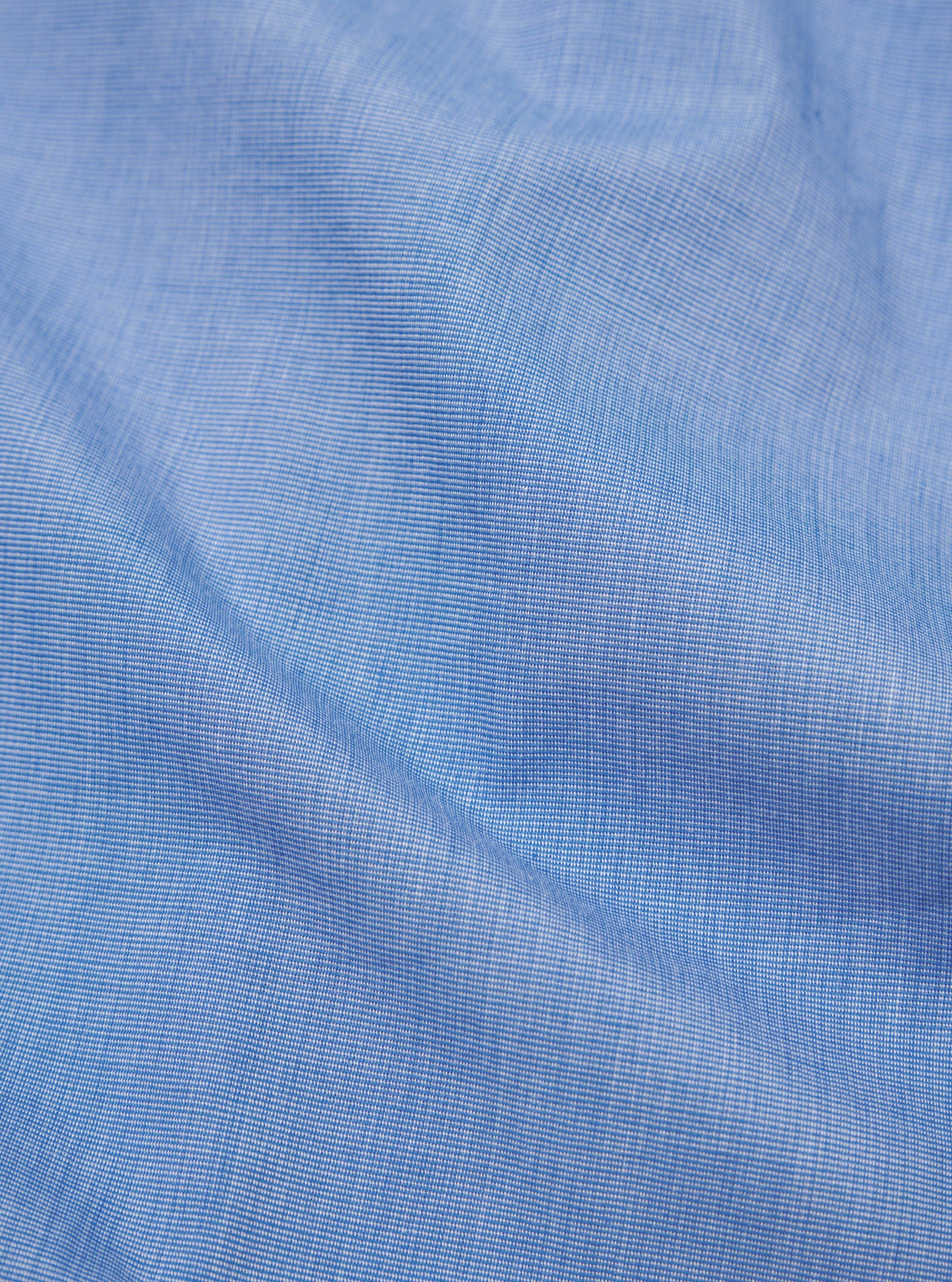 Close-up of the Blue End On End Cotton Garage Shirt fabric. The light blue cotton has a subtle texture. 