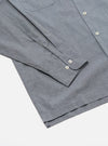 Close-up of the Grey End On End Cotton Garage Shirt on a white surface. The shirt has a pocket and buttoned cuffs.