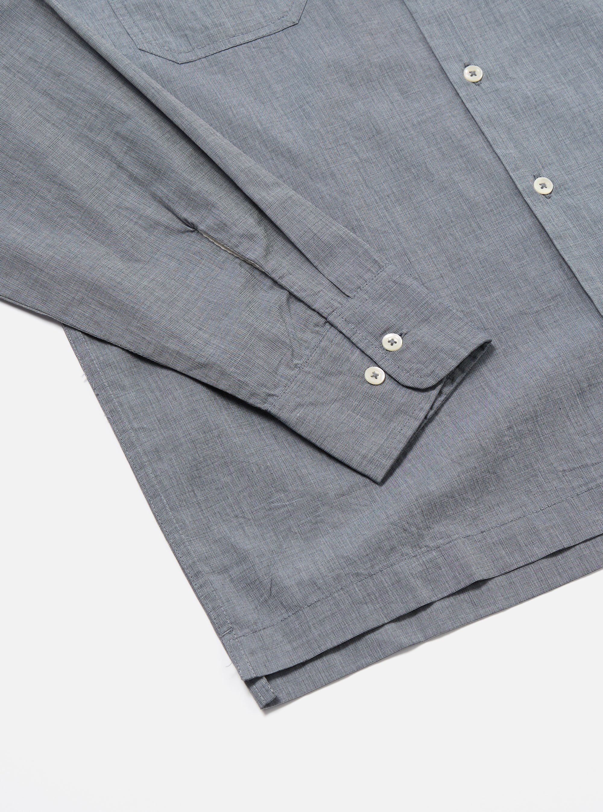 Close-up of the Grey End On End Cotton Garage Shirt on a white surface. The shirt has a pocket and buttoned cuffs.