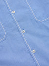 Close-up of the Blue End On End Cotton Utility SS Shirt. Shows the light blue cotton fabric, white buttons, and white stitching on the pockets and placket. 