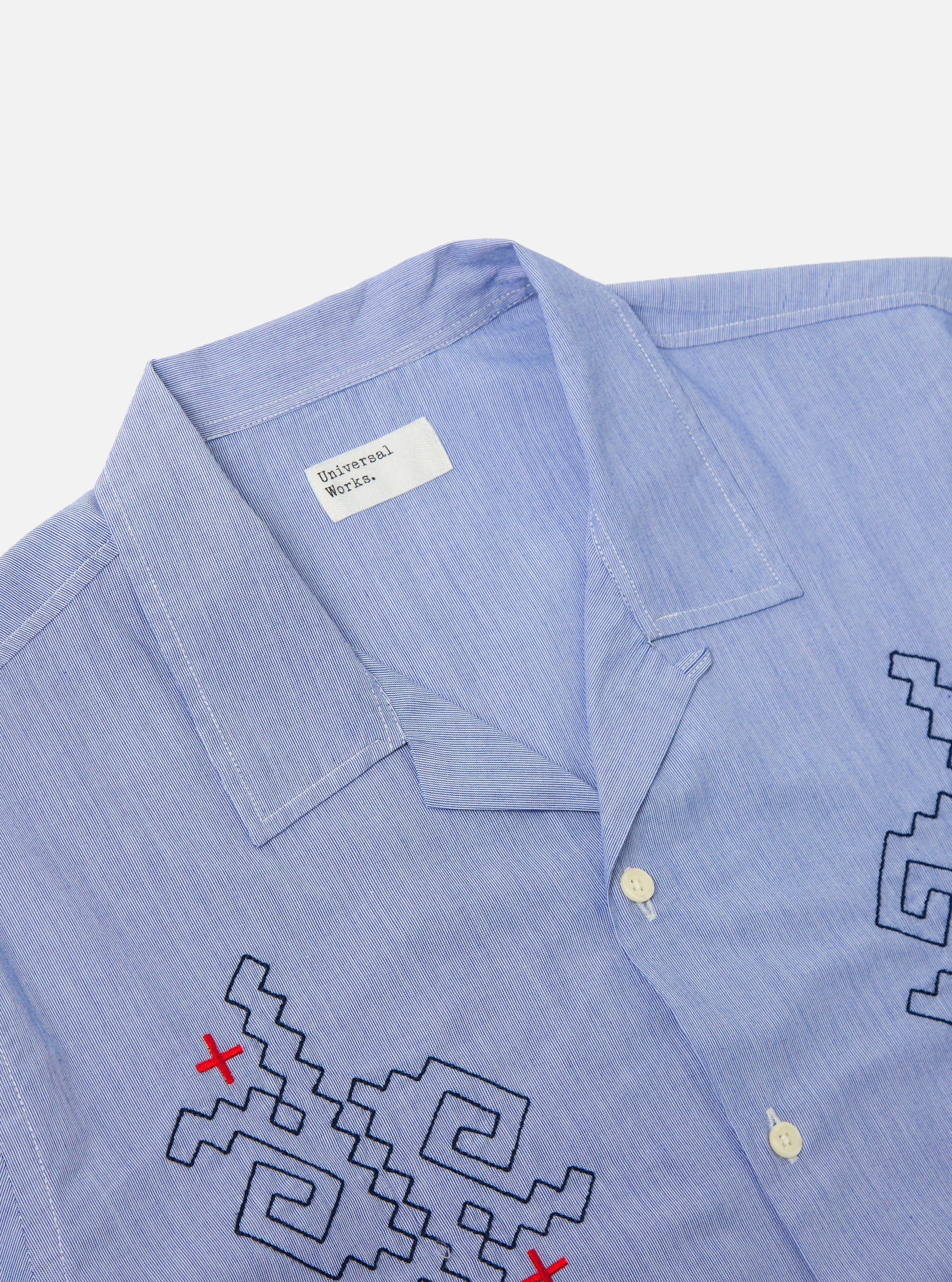 Close-up of the Blue Classic Stripes Road Trip Shirt on a white background. The shirt is light blue with black and red embroidery.