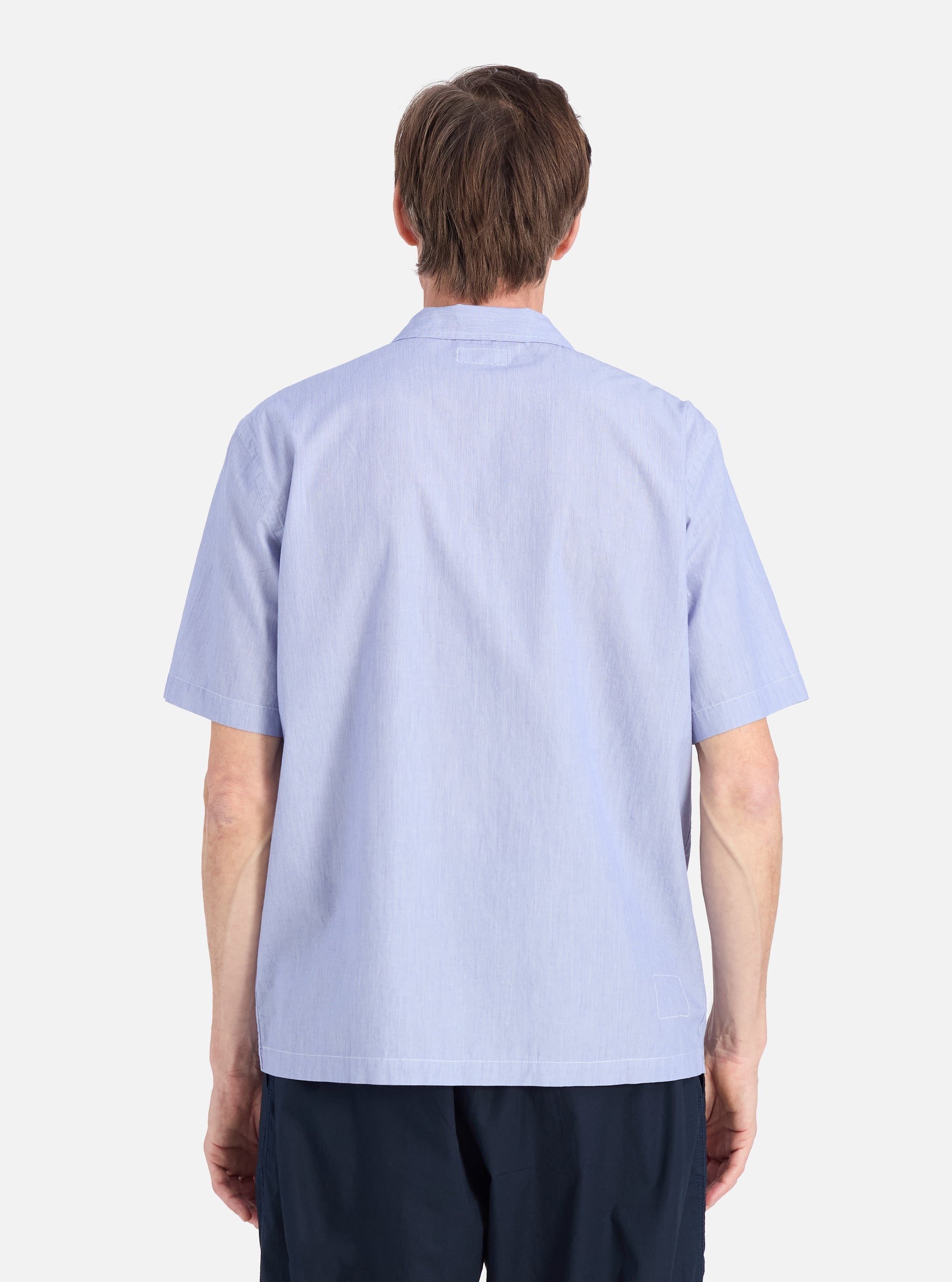 Back view of a man wearing a Blue Classic Stripes Road Trip Shirt. The shirt is light blue with subtle stripes. The background is a plain white studio setting.