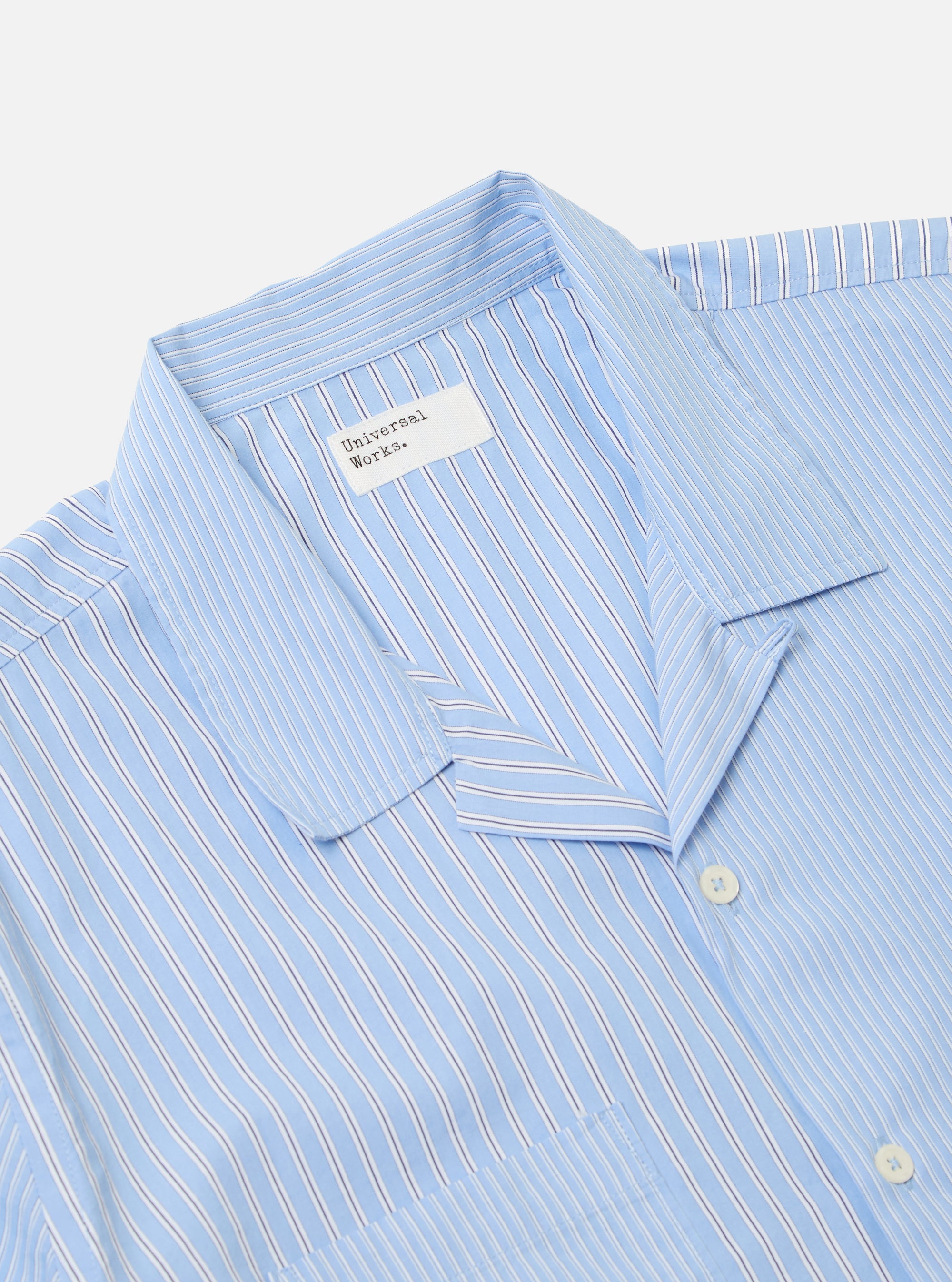 Close-up of the Blue Vila Stripes Sal Road Shirt on a white background. The shirt features light blue, white, and navy stripes. The collar and pocket are visible.