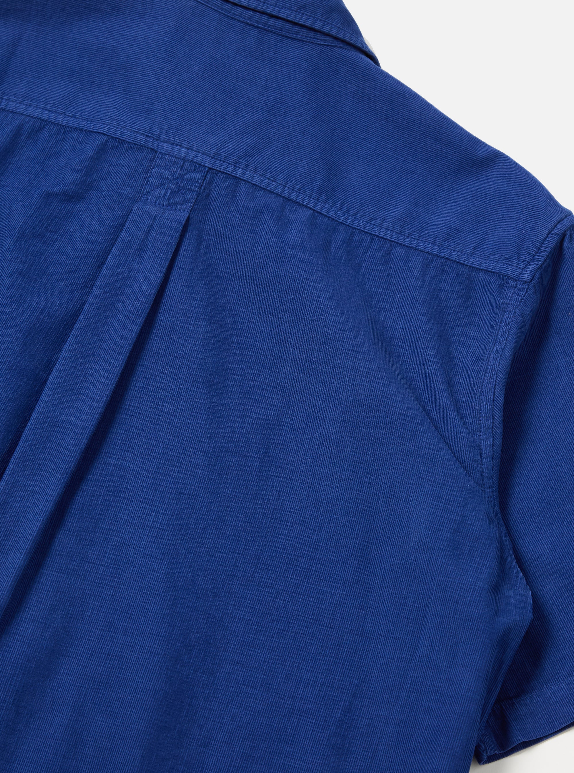 Close-up of the back of a Work Blue Summer Cord Tech Overshirt. The blue corduroy fabric is visible against a white background, highlighting the shirt's texture and construction.