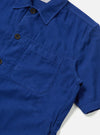 Close-up of the Work Blue Summer Cord Tech Overshirt on a white background. The blue corduroy shirt has a pocket and brown buttons.