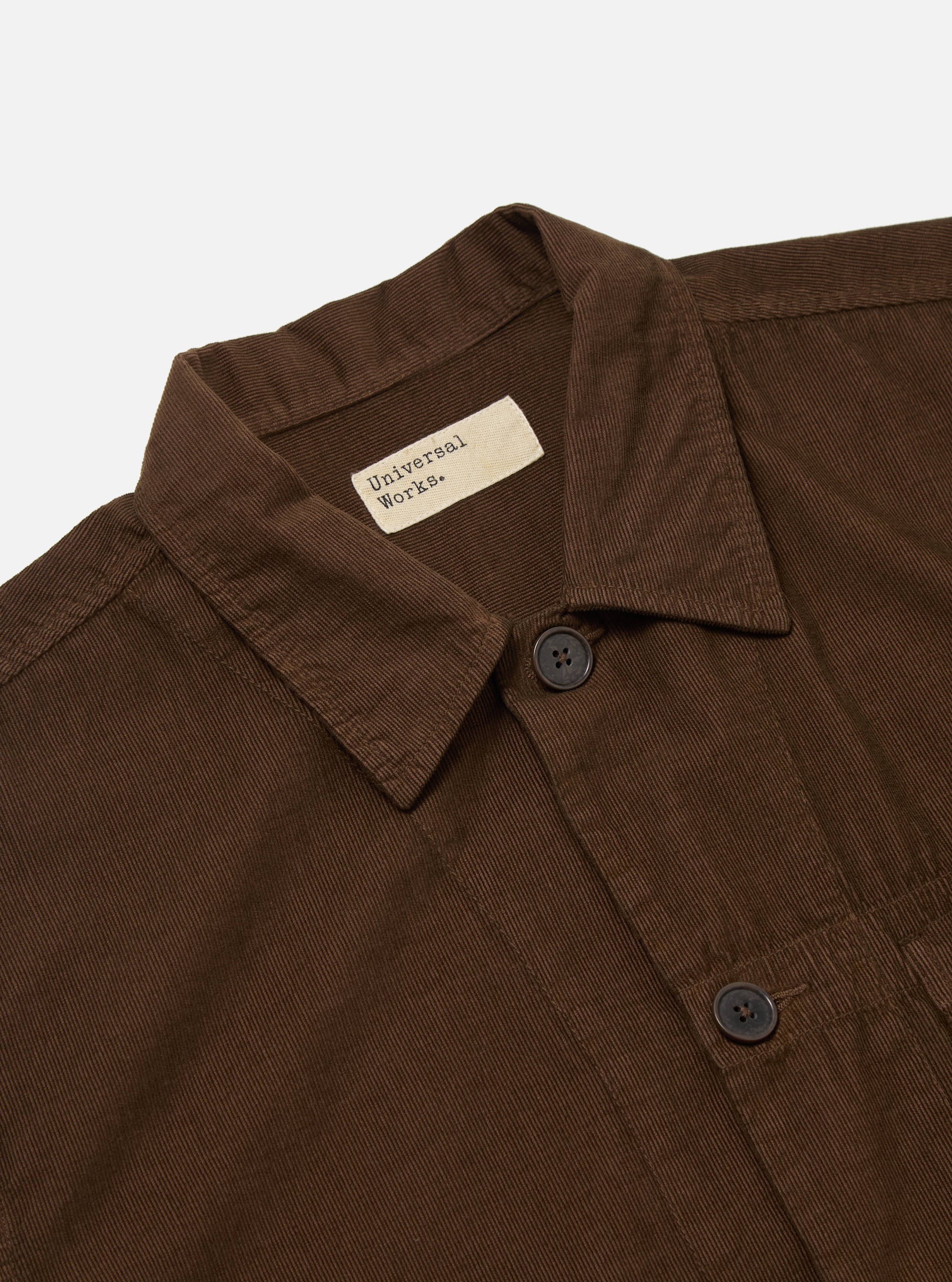 Close-up of the Khaki Summer Cord Tech Overshirt on a white background. The brown corduroy texture is visible, along with the collar, buttons, and Universal Works label.