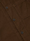 Close-up of the Khaki Summer Cord Tech Overshirt, showcasing its brown corduroy texture, button details, and pocket. Shot on a flat, neutral surface.