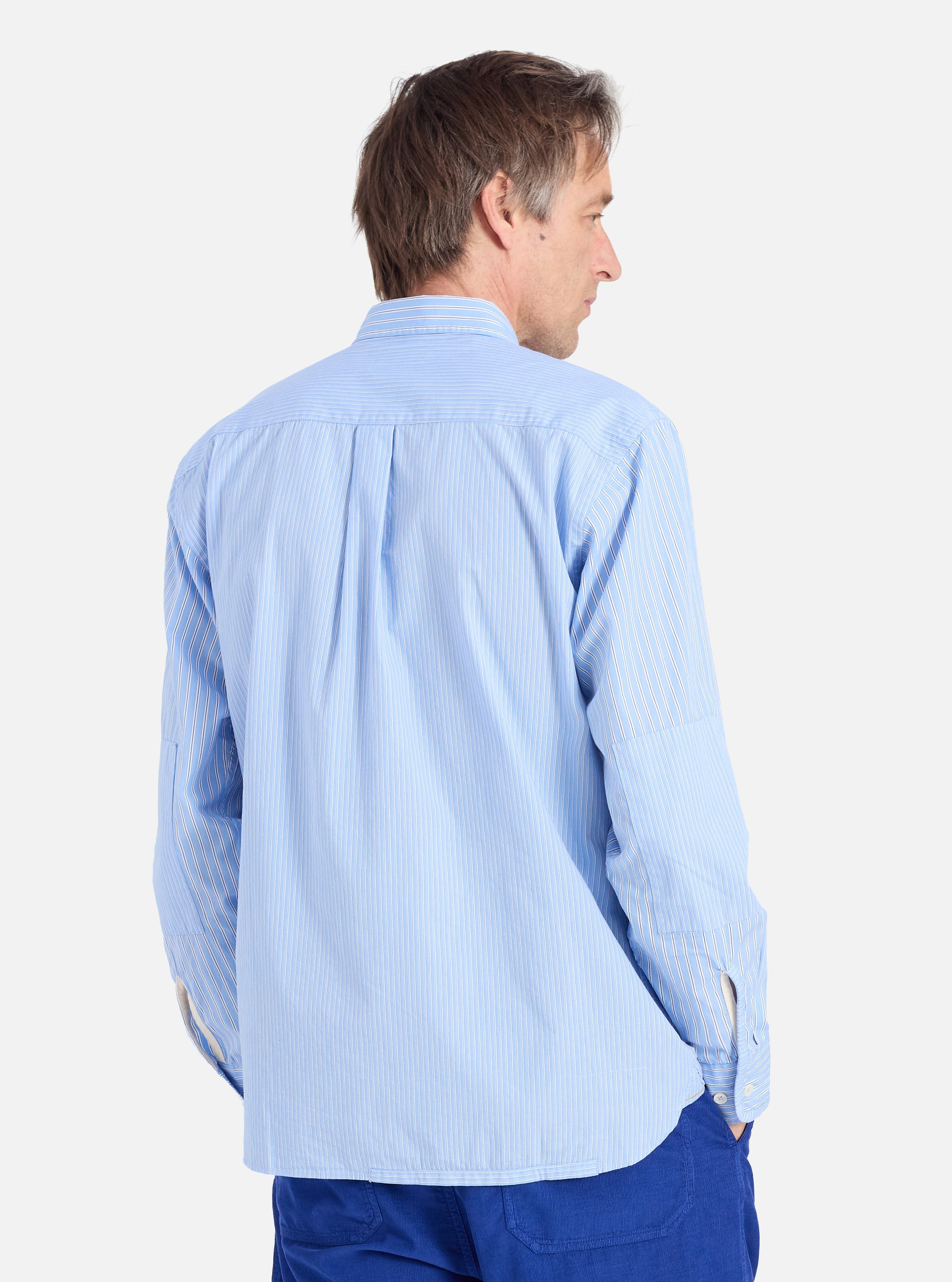 Back view of a man wearing a Blue Vila Stripes Patched Shirt. The shirt is light blue with thin white stripes. Shot against a white background.