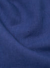 Close-up of the blue linen cotton shirting Travail Overshirt fabric. The material is draped to show texture and color. 