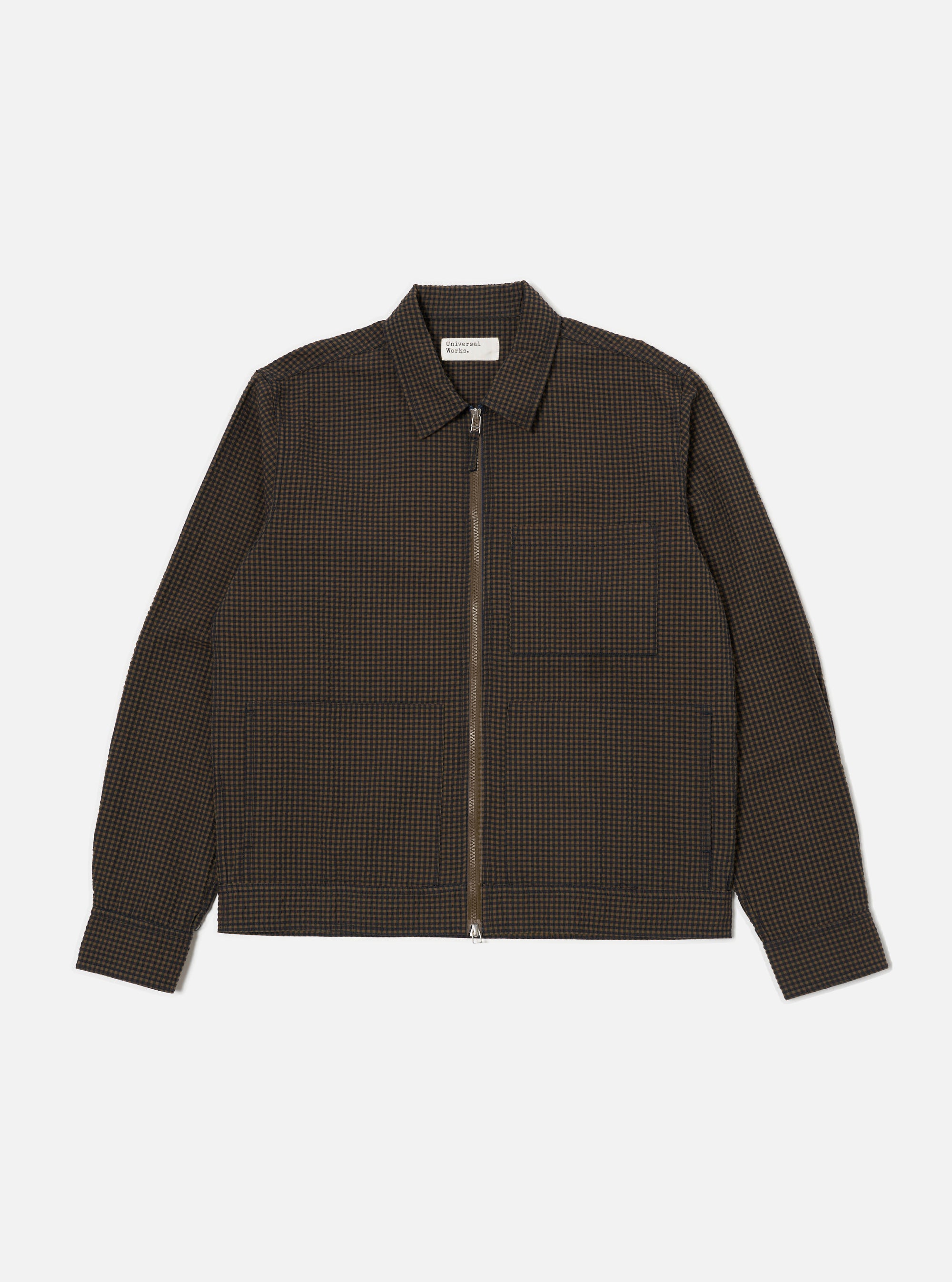 Close-up of the Navy Japanese Seersucker Zip Uniform Jacket on a white background. The jacket is a brown and black checkered pattern with a zip-up front and two pockets.