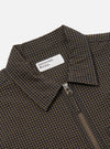 Close-up of the Navy Japanese Seersucker Zip Uniform Jacket. The jacket features a navy and brown checkered pattern, a silver zipper, and a white label. The background is a plain white.