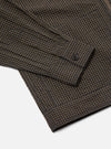 Close-up of the Navy Japanese Seersucker Zip Uniform Jacket showing the sleeve and hem. The jacket has a brown and navy checkered pattern. The background is a plain white.