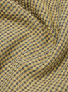 Close-up of the yellow Japanese seersucker zip uniform jacket fabric. The material is a checkered pattern of yellow, brown, and blue. The fabric is wrinkled.