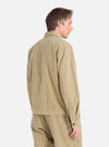 A man models the Yellow Japanese Seersucker Zip Uniform Jacket in a studio shot. The jacket is yellow with a subtle checkered pattern and a zip front.