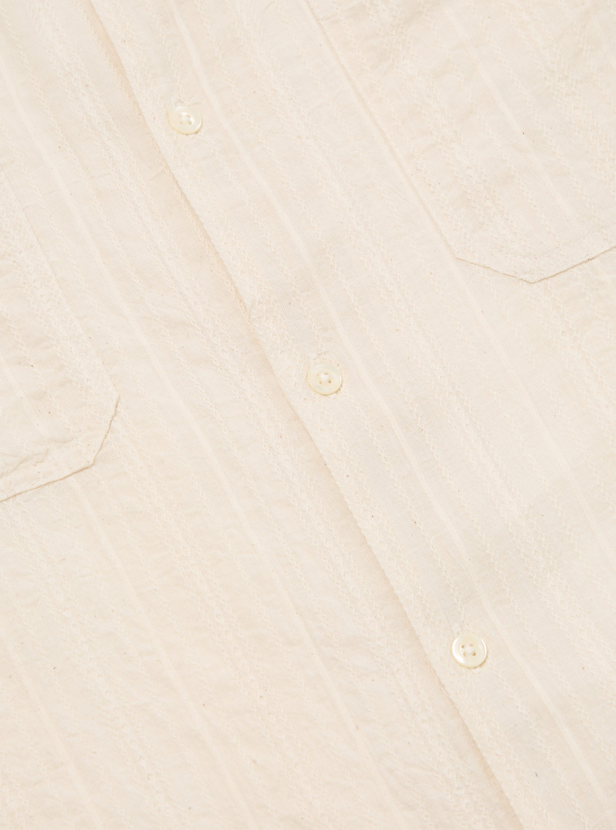 Close-up of the Ecru Acapulco Weave Work Shirt, showing the textured fabric, button closures, and chest pockets. The shirt is laid flat on a neutral surface.