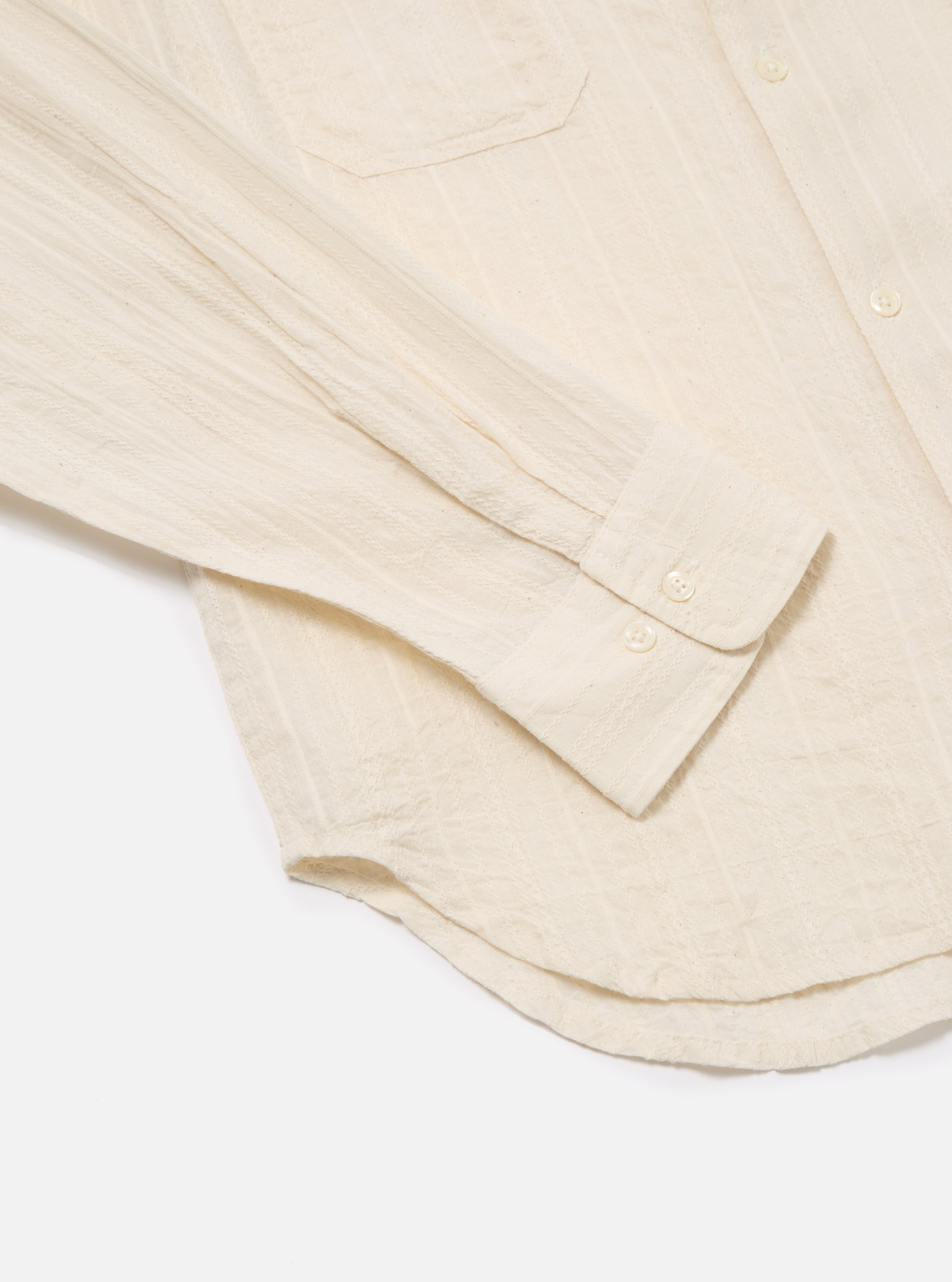 Close-up of the Ecru Acapulco Weave Work Shirt on a white surface. The shirt is ecru-colored with a subtle weave pattern and button details.