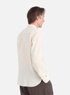 Profile of a man wearing an Ecru Acapulco Weave Work Shirt. The shirt is a light cream color with a textured weave. Shot against a white background.
