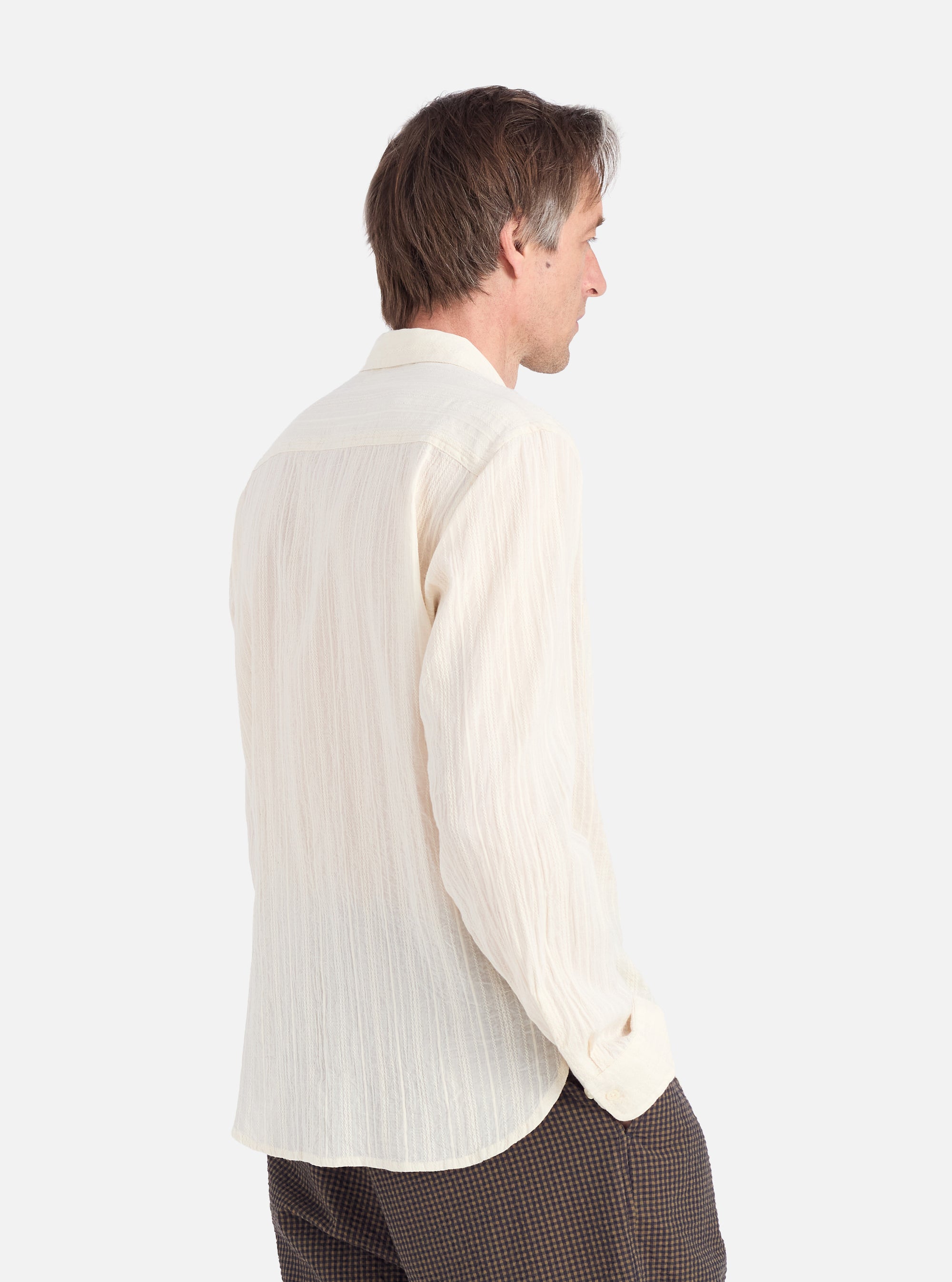 Profile of a man wearing an Ecru Acapulco Weave Work Shirt. The shirt is a light cream color with a textured weave. Shot against a white background.