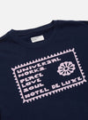 Close-up of the Navy/Pink Single Jersey Pickup Print Tee. The navy tee features a pink graphic print. Single jersey material. 