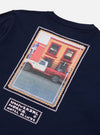 Close-up of the Navy/Pink Single Jersey Pickup Print Tee. The tee is navy with a pink-bordered print of a pickup truck in front of a building. 