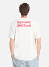 Back view of a model wearing the Ecru/Red Single Jersey Pickup Print Tee. The tee is ecru with a red print on the back. Shot against a white background.