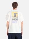 Back view of a model wearing an Ecru/Yellow Single Jersey Pickup Print Tee. The tee has a graphic print. Shot against a white backdrop.
