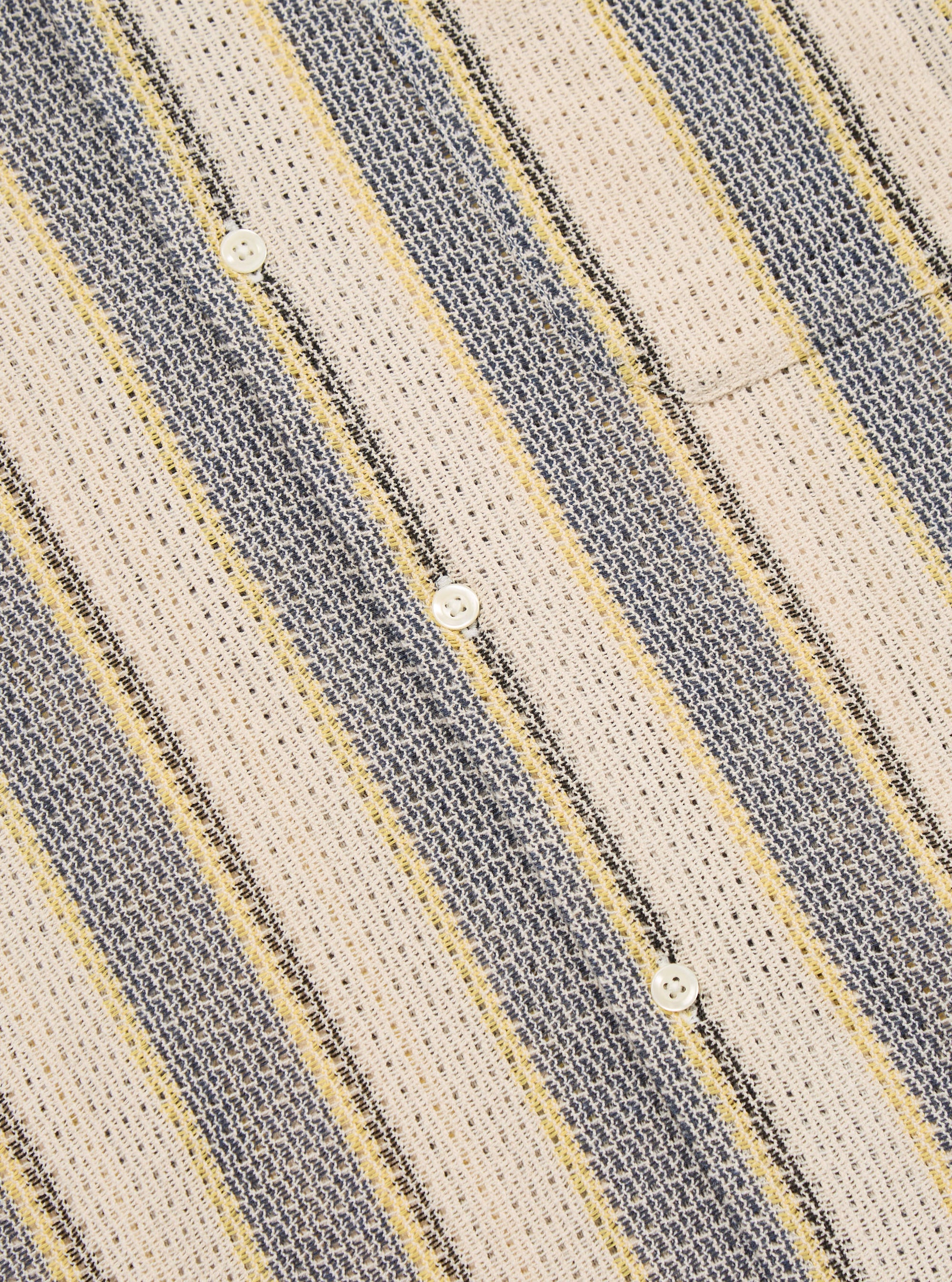 Close-up of the Grey/Yellow Cotton Lattice Road Shirt. The shirt features a lattice pattern with grey, yellow, and white stripes. Made of cotton, with white buttons. 