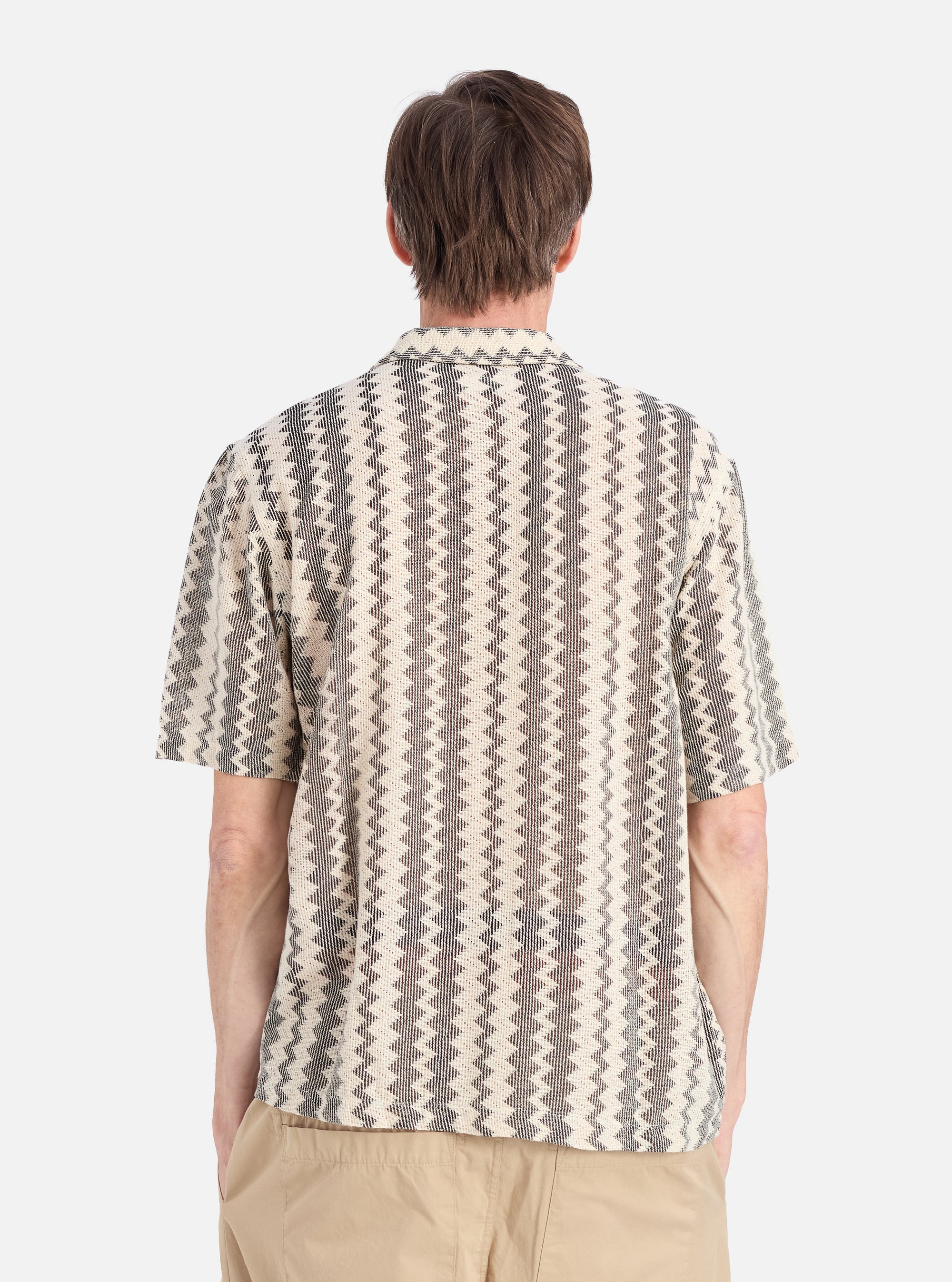 Back view of a man wearing a Charcoal Cotton Lattice Road Shirt. The shirt has a geometric pattern. Shot on a white background.