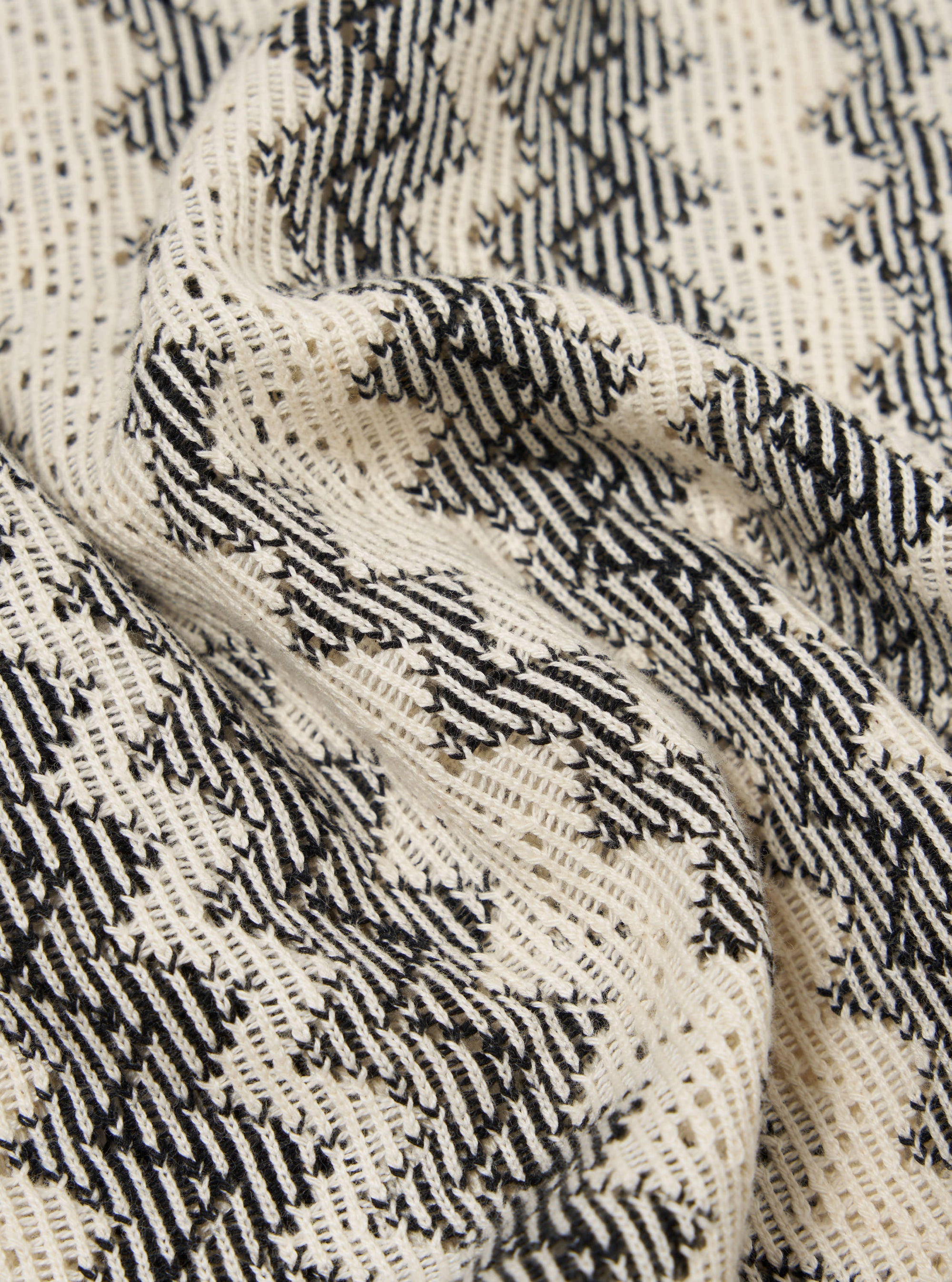 Close-up of the Charcoal Cotton Lattice Road Shirt, showing the fabric's texture and lattice pattern in charcoal and cream. The shirt is draped on a flat surface.