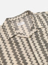Close-up of the Charcoal Cotton Lattice Road Shirt. The shirt has a black and cream lattice pattern. Cotton material. The shirt is laid on a white surface.