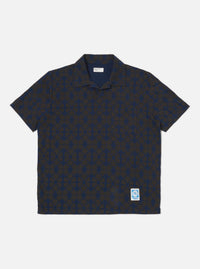 The Navy/Brown Mitla Print Jersey Newlyn Polo on a white background. The polo features a navy and brown geometric print and short sleeves.