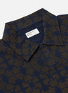 Close-up of the Navy/Brown Mitla Print Jersey Newlyn Polo on a plain background. The polo features a unique geometric pattern and a classic collar.