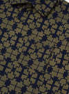 Close-up of the Navy/Mud Mitla Print Jersey Newlyn Polo. The polo features a navy and mud geometric print. The fabric is soft jersey. A chest pocket is visible.