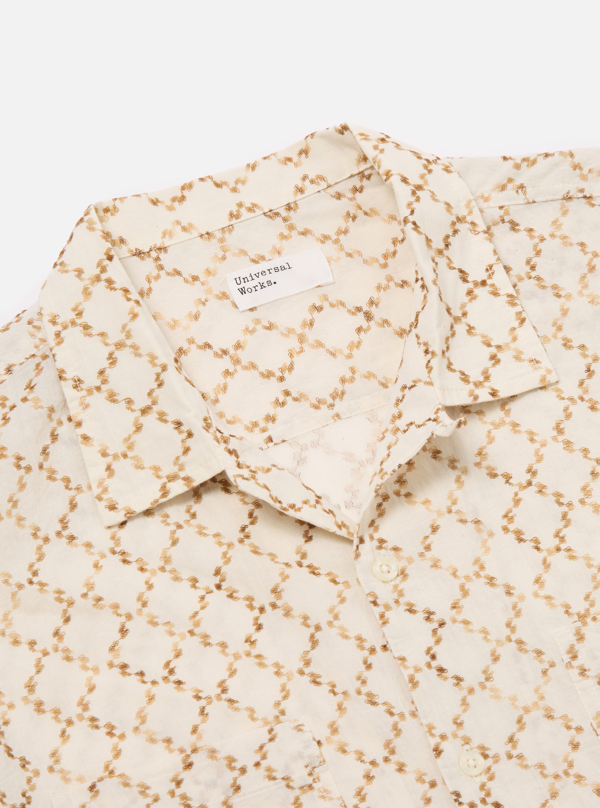 Close-up of the Camel Mitla Weave Work Shirt on a white background. The shirt is off-white with a brown woven pattern. The collar is visible.