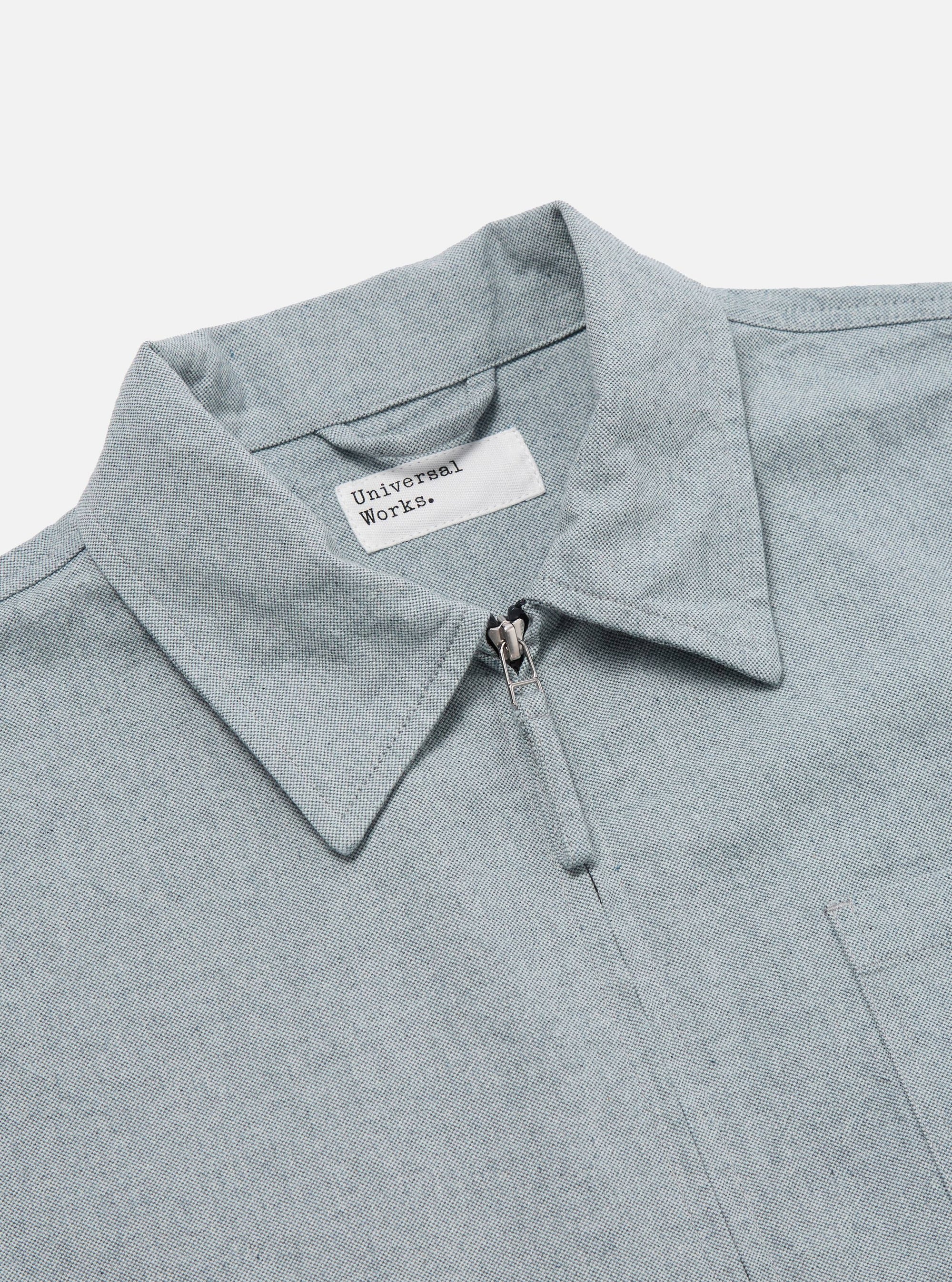 Close-up of the Indigo Reworked Jean Cloth Rose Bowl Jacket in light blue denim. Features a collared neck, front zipper, and chest pocket. Shot on a white background.