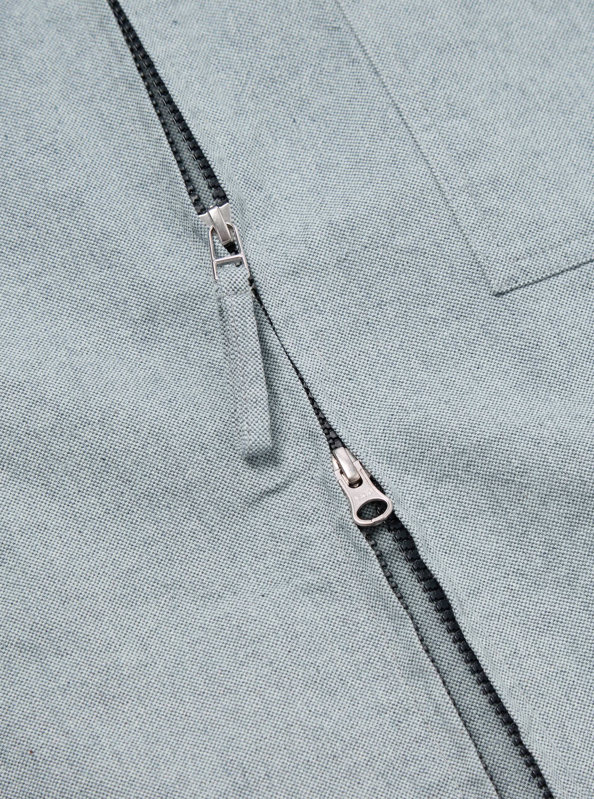 Close-up of the Indigo Reworked Jean Cloth Rose Bowl Jacket, showcasing the light blue denim texture and silver zipper. The jacket is laid flat, highlighting the material.