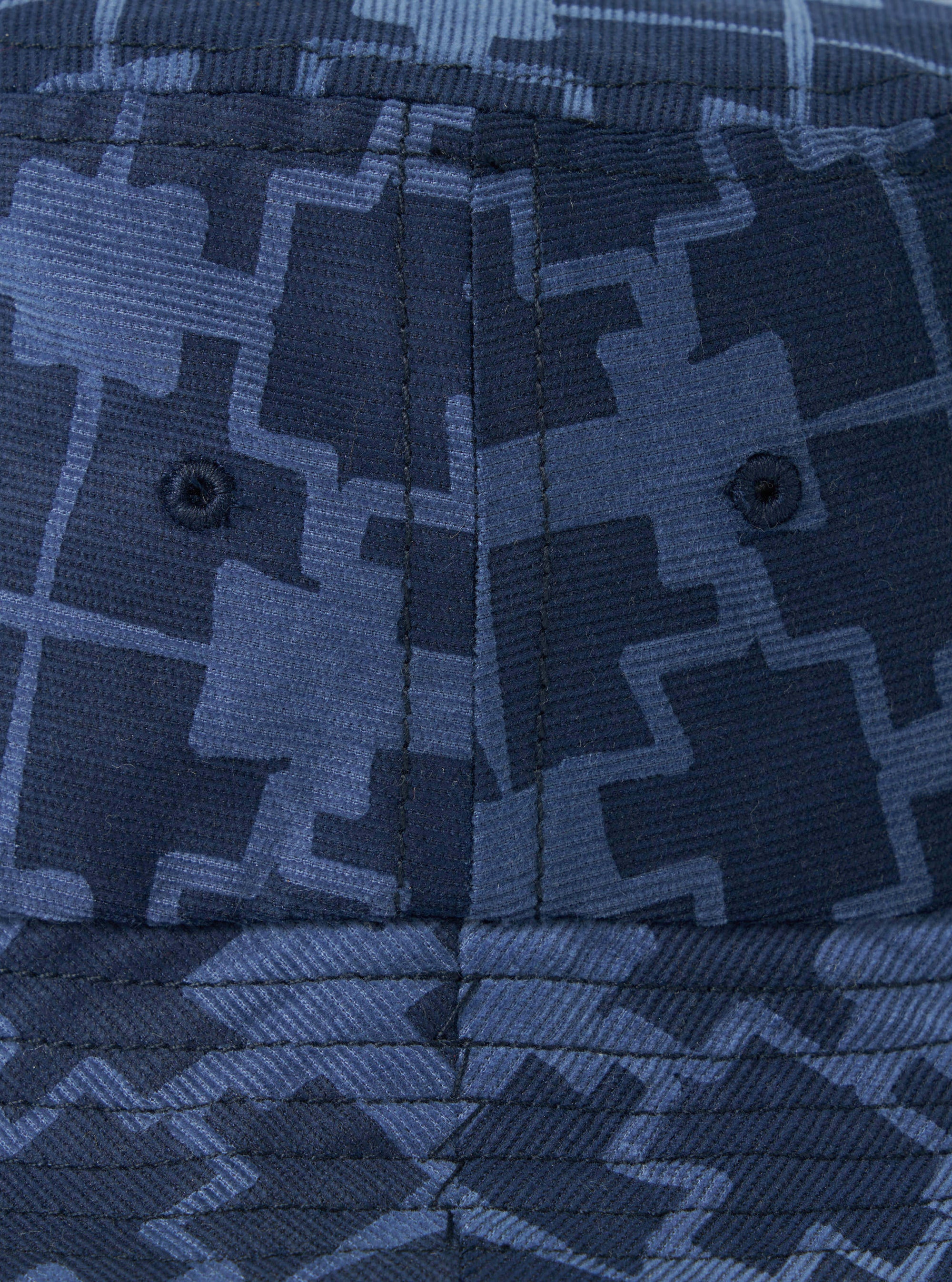 Close-up of the Navy Mitla Print Cord Beach Hat, showcasing its corduroy texture and geometric pattern in varying shades of blue. The hat features stitched seams and ventilation eyelets.