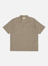 The Olive Dobby Check Road Shirt, a short-sleeve button-down, is laid flat on a white background. The shirt features an olive and beige check pattern and a relaxed fit.
