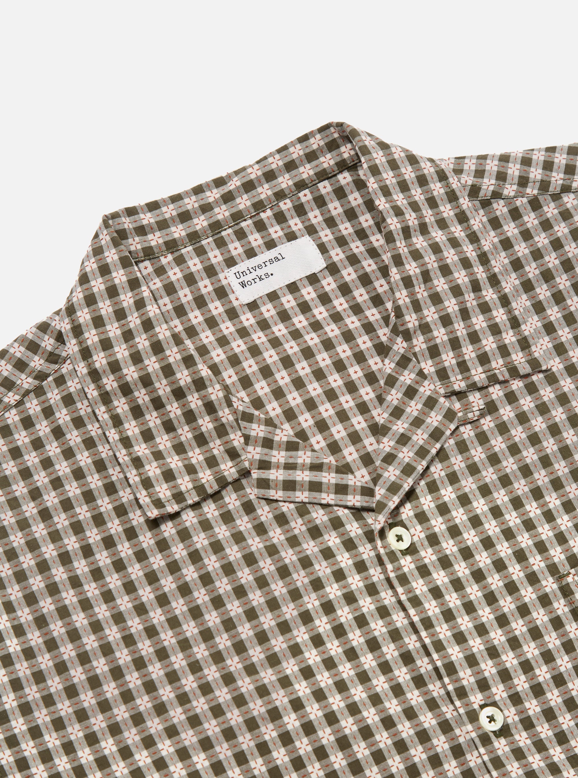 Close-up of the Olive Dobby Check Road Shirt on a white background. The shirt features an olive and white check pattern with small red accents. The collar and buttons are visible.