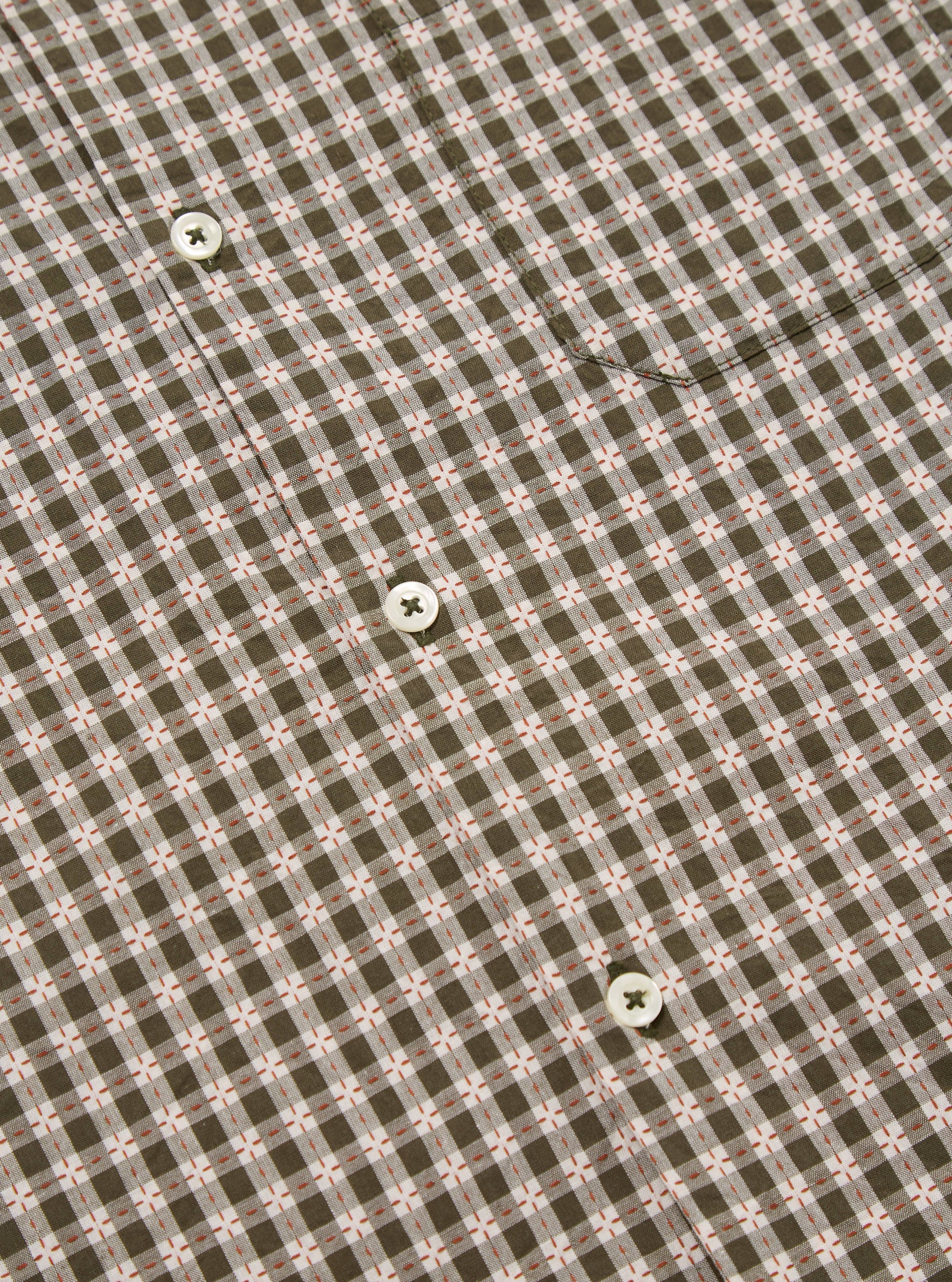 Close-up of the Olive Dobby Check Road Shirt, showcasing its olive and white check pattern with small red accents. White buttons are visible on the shirt's front.