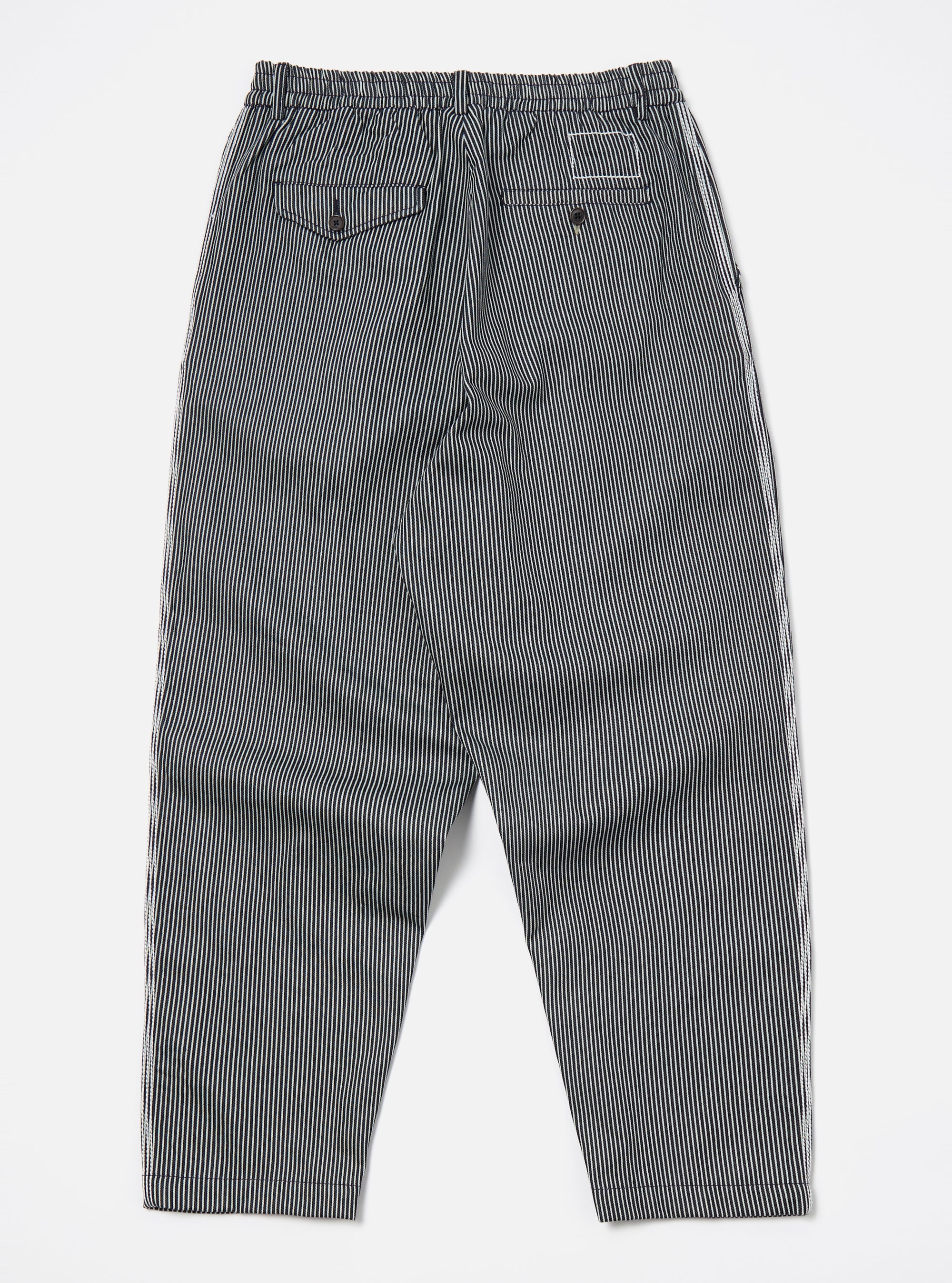 Back view of Indigo Hickory Stripe Denim Pleated Track Pant on a white surface. The pants have a relaxed fit and feature a striped pattern.