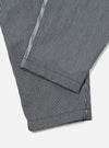 Close-up of the Indigo Hickory Stripe Denim Pleated Track Pant on a white surface, showcasing the fabric's texture and pleated design.
