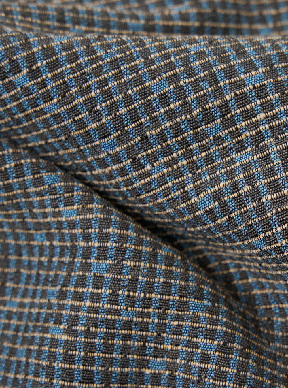 A close-up fabric swatch of the Grey/Blue Jacquard Weave Field Jacket shows a detailed view of the textured material. The intricate jacquard weave features a geometric pattern in shades of grey and blue.