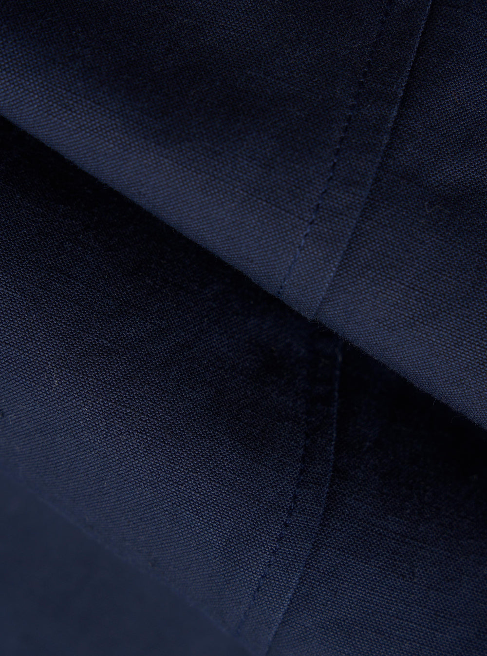 A close-up fabric swatch of the Navy Linen Slub Weave Manor Jacket shows a deep navy blue color and a textured slub weave. The fabric has a visible, irregular grain characteristic of linen.