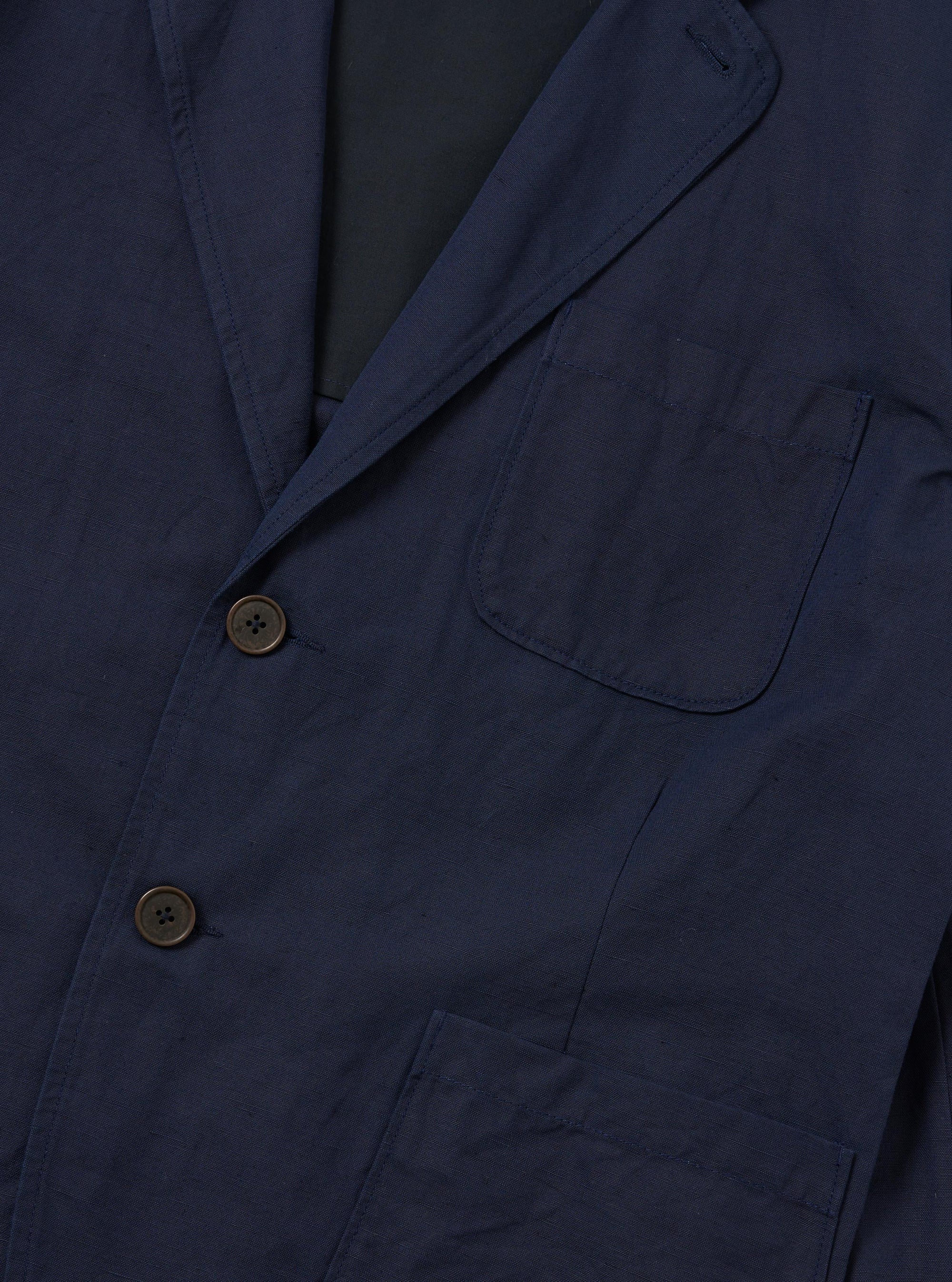 The Navy Linen Slub Weave Two Button Jacket is shown from the back, laid flat against a plain white background. The image highlights the jacket's structured shoulders, a single central vent at the hem, and the textured, irregular slubbed appearance of the navy blue linen-cotton blend fabric.